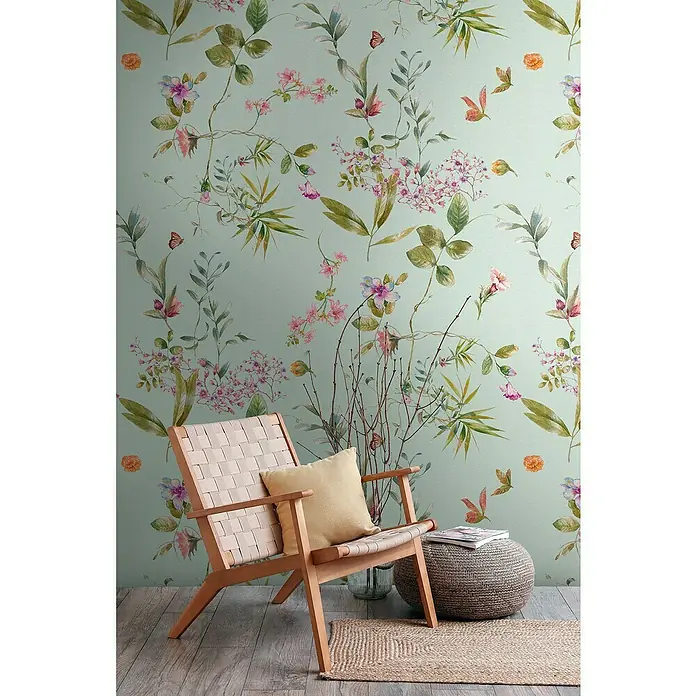 A.S. Création The Wall 3 Fototapete Blumen III - B x H: 159 x 280 cm, Vlies - Elegantes Wohnzimmer mit einem modernen Holzstuhl mit gewebter Sitzfläche, Kissen und einem Hocker auf einem Teppich vor einer floralen Wand.