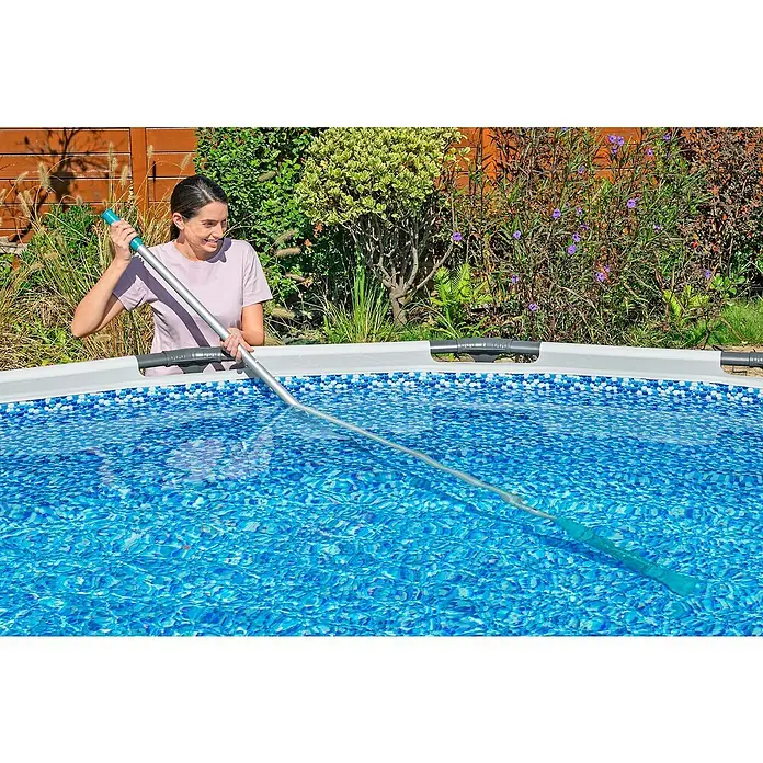 Bestway Poolsauger-Set AquaSurge - Türkis - Frau reinigt Pool mit Poolkescher. Der Poolkescher hat einen blauen Griff und einen silbernen Stab und sorgt für einen sauberen Pool.