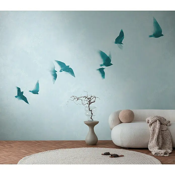 A.S. Création The Wall 3 Fototapete Himmel - B x H: 371 x 280 cm, Vlies - Ein stilvolles Wohnzimmer mit einem cremefarbenen Sofa, einem Beistelltisch und einer Wanddekoration mit Vogelmotiven.