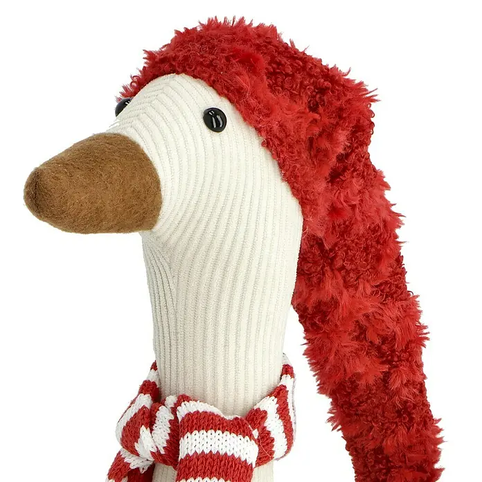 Dekofigur Weihnachtsgans - L x B x H: 28 cm x 11 cm x 70 mm, Textil - Nahaufnahme einer festlichen Stofftiergans mit roter Mütze und gestreiftem Schal, die saisonalen Charme versprüht. Ideale Weihnachtsdekoration.