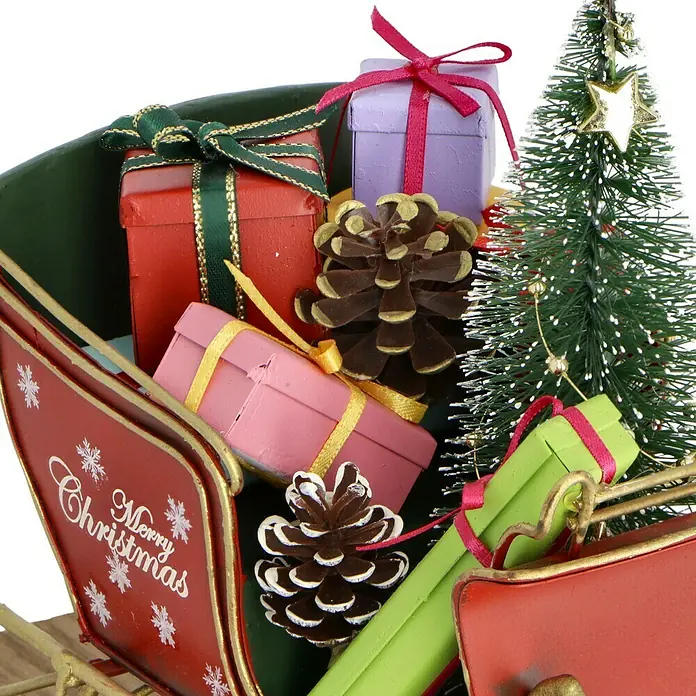 Dekofigur Weihnachtsschlitten - L x B x H: 22 x 10,5 x 18 cm, Metall - Nahaufnahme eines festlichen Schlittens mit Geschenken, Tannenzapfen und einem kleinen Weihnachtsbaum, ideal für weihnachtliche Dekorationen.