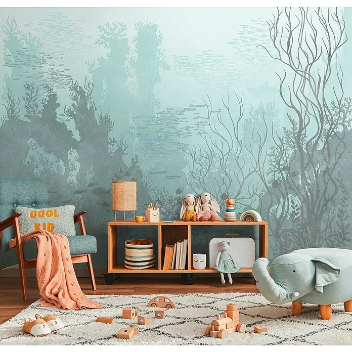 A.S. Création The Wall 3 Fototapete Unterwasser - B x H: 371 x 280 cm, Vlies - Ein Kinderzimmer mit einem mintfarbenen Sessel, einem Bücherregal auf Rädern und einem Elefantenhocker, der eine gemütliche und spielerische Atmosphäre schafft.