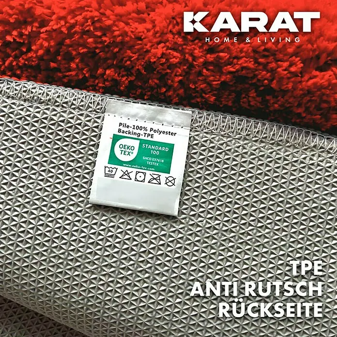Floordirekt Badteppich Atlantis - 120 x 70 cm, Rot, 100% Polyester - Nahaufnahme eines Karat-Teppichs mit roter Oberseite und rutschfester TPE-Rückseite, versehen mit einem Öko-Tex-Siegel für Qualität.