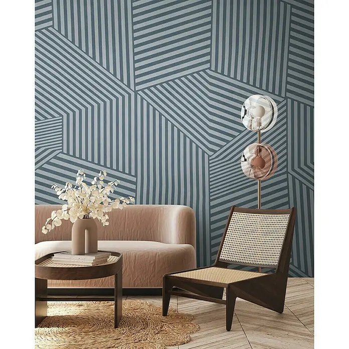 A.S. Création The Wall 3 Fototapete Bewegte Grafik - B x H: 371 x 280 cm, Vlies - Wohnzimmer-Szene mit einem stilvollen Sessel, einem runden Tisch und einer modernen Stehlampe vor einer geometrischen Tapete.