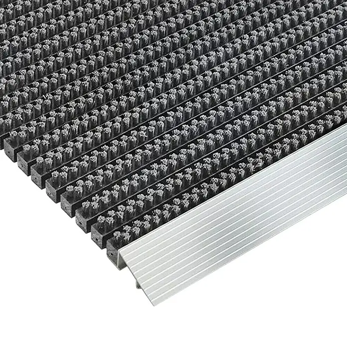 Fußmatte Profi Brush - Grau, 90 x 60 cm, 100 % Nylon - Eine Nahaufnahme einer Fußmatte mit einem silbernen Rand. Die Oberfläche der Matte ist rau und strukturiert.