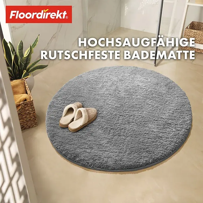 Floordirekt Badteppich Sky - 95 x 95 cm, Silbergrau, 100% Polyester - Das Bild zeigt eine graue, runde Badematte mit dem "Floordirekt"-Logo und dem Text "Hochsaugfähige, rutschfeste Badematte".