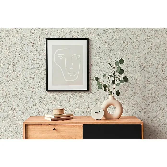 A.S. Création Pintwalls 2 Vliestapete Blumen - Creme-Beige-Braun, Floral, 10,05 x 0,53 m - Nahaufnahme eines stilvollen Holzschranks mit minimalistischer Dekoration wie einer Vase, einer Uhr und einem gerahmten Kunstwerk.