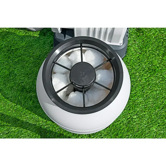Bestway Flowclear Filterbälle - 500 g - Nahaufnahme eines runden Teichfilters mit weißen Filterbällen und schwarzem Gitter auf grünem Gras.