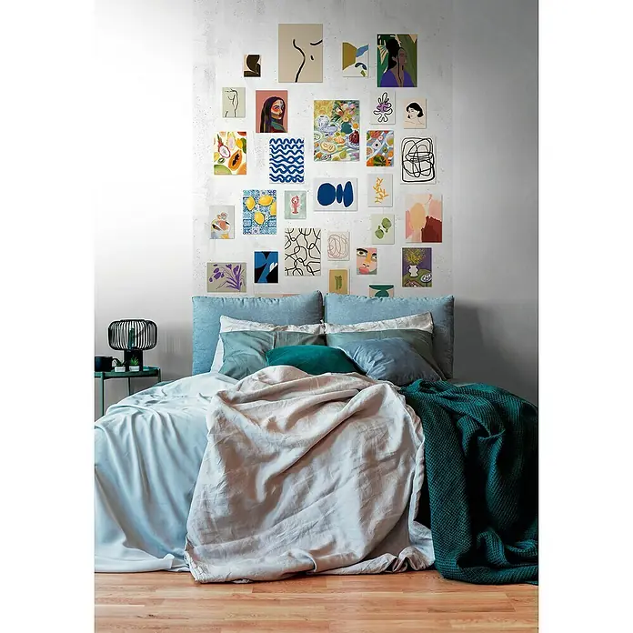 A.S. Création The Wall 3 Fototapete Bilderwand - B x H: 159 x 280 cm, Vlies - Ein Schlafzimmer mit einem mit farbenfrohen Kunstdrucken dekorierten Wandhintergrund und einem mit blauen, grauen und grünen Textilien bedeckten Bett.