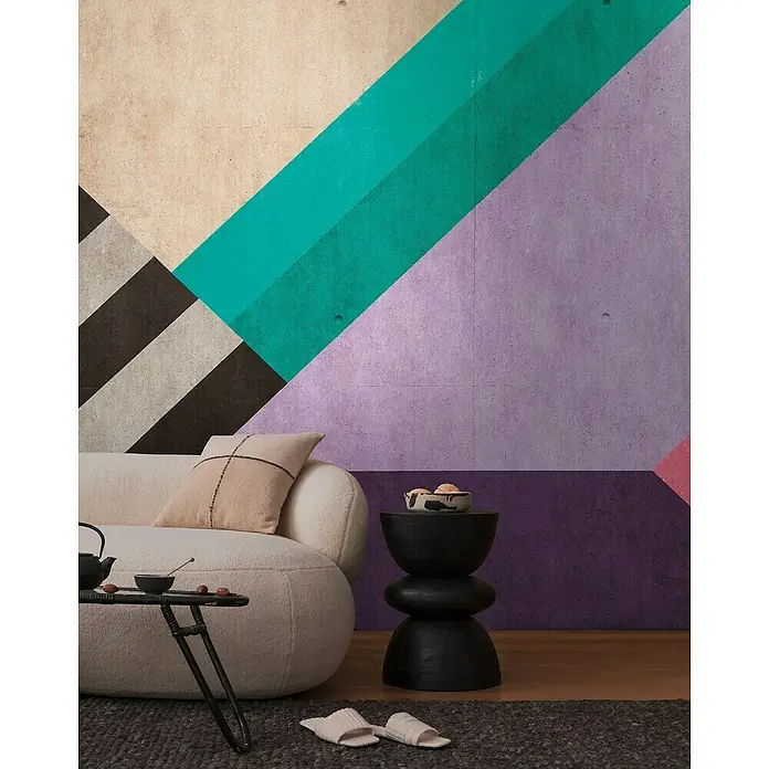 A.S. Création The Wall 3 Fototapete Grafik - B x H: 371 x 280 cm, Vlies - Dekorative Innenaufnahme mit farbiger geometrischer Wand, Sofa, Tisch und Pantoffeln für eine gemütliche Atmosphäre.