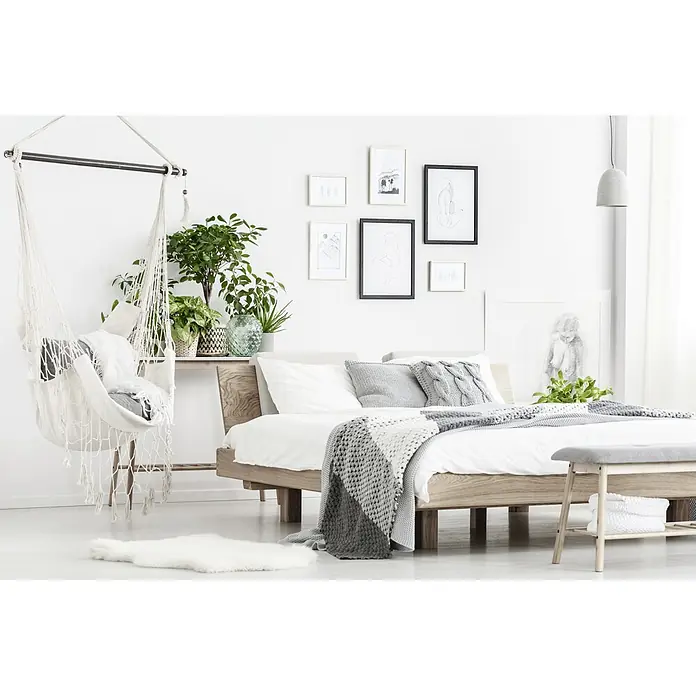 swingcolor Wandfarbe Silikat-Innenfarbe - Weiß, Matt, 10 l, Konservierungsmittelfrei - Gemütliches Schlafzimmer mit Hängekorb, Holzbetonung und grau-weißen Akzenten für eine entspannte Atmosphäre.