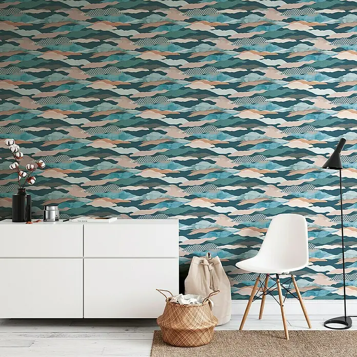 A.S. Création Pintwalls 2 Vliestapete Wolken-Wellen - Blau-Grün-Rosa, Grafisch, 10,05 x 0,53 m - Elegante Innenaufnahme mit gemusterter Tapete. Weißes Sideboard mit Dekor, Stuhl und Stehlampe schaffen ein stilvolles Wohnambiente.