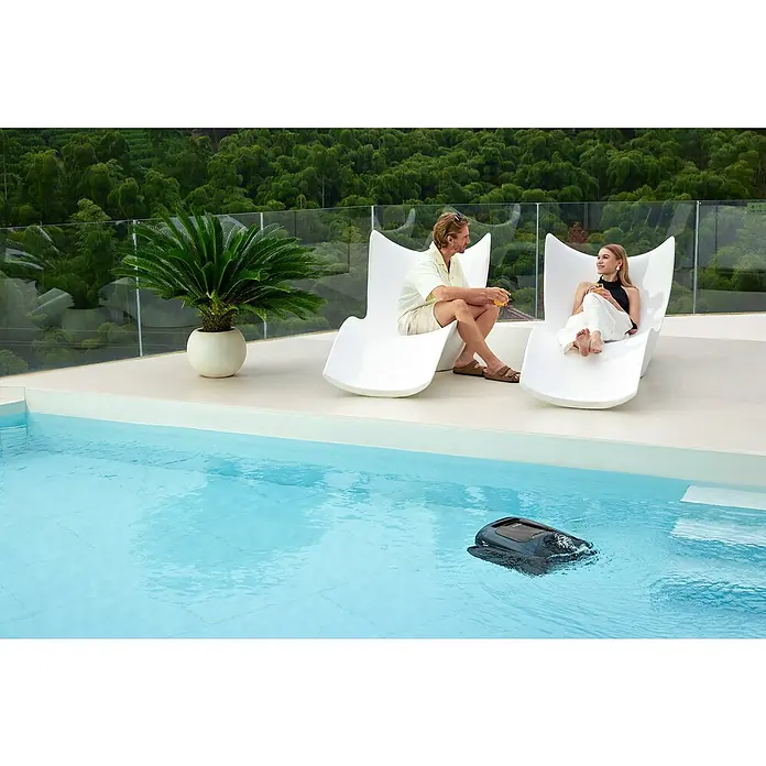 Beatbot Poolroboter AquaSense 2 Pro - Akkubetrieben, Passend für: Pools bis 360 m² Grundfläche, Filterleistung: 20.800 l/h - Ein Poolreinigungsroboter schwimmt im Pool, während sich ein Paar auf Liegestühlen amüsiert.