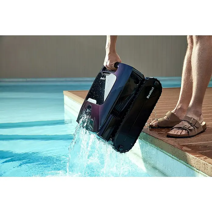 Beatbot Poolroboter AquaSense 2 Pro - Akkubetrieben, Passend für: Pools bis 360 m² Grundfläche, Filterleistung: 20.800 l/h - Ein Poolroboter wird von einer Person am Pool hochgehoben. Der Poolroboter ist dunkelblau und hat den Schriftzug Beatbot.
