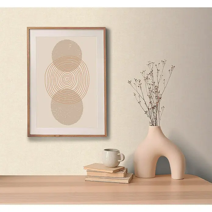 A.S. Création Metropolitan Stories Hot Spots Vliestapete - Creme-Beige, Uni, 10,05 x 0,53 m - Minimalistisches Kunstwerk mit konzentrischen Kreisen und Erdtönen, gerahmt und auf einer Holzkommode platziert, neben einer Vase und Büchern.