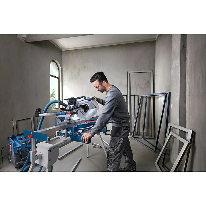Bosch Professional Kapp- & Gehrungssäge GCM 340-305D - 1.800 W, Durchmesser Sägeblatt: 305 mm, Leerlaufdrehzahl: 4.050 U/min - Ein Handwerker bedient eine Bosch Kapp- und Gehrungssäge in einer Werkstatt, um Metallrahmen präzise zuzuschneiden.