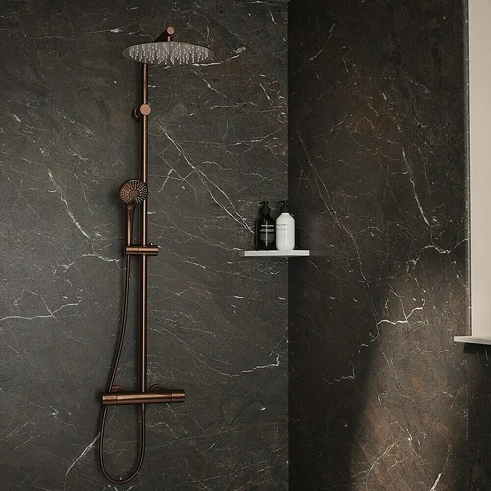 Wetwall Wandpaneel Elite - 16 x 242 cm, Rosso Levanto, Abgerundete Kante - Elegante Dusche mit Armatur in Kupferoptik vor dunkler Marmorwand. Moderne Badgestaltung mit minimalistischem Design und praktischem Duschregal.