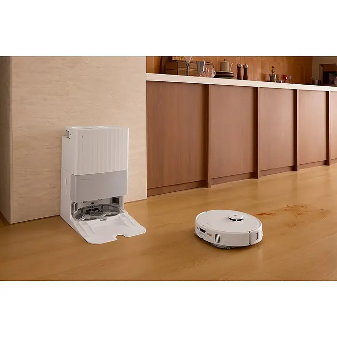 Roborock Saugwischroboter Qrevo Edge 5V1 White - Saugkraft: 18.500 Pa, Akkulaufzeit: 180 min, Fassungsvermögen Roboter: 325 ml, Weiß - Ein weißer Roboterstaubsauger und seine Ladestation stehen auf einem Holzboden in einer Küche.