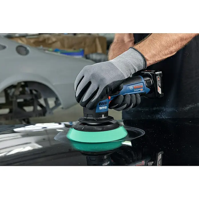 Bosch Professional Akku-Poliermaschine GPX 12V-125 - 12 V, Ohne Akku, Leerlaufdrehzahl: 1.400 U/min - 7.000 U/min - Ein Akku-Polierer von Bosch Professional GFX 12V-75 wird von einer Person auf einer dunklen Oberfläche verwendet.