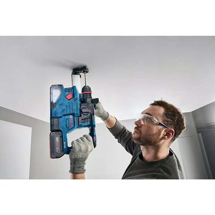 Bosch Professional AMPShare 18V Akku-Bohrhammer GBH 18V-22X - 18 V, Ohne Akku, 2 J - Ein Mann bohrt mit einer Bosch GBH 18V-28 DC Professional Akku-Bohrhammer in die Decke, geschützt durch Handschuhe und Schutzbrille.