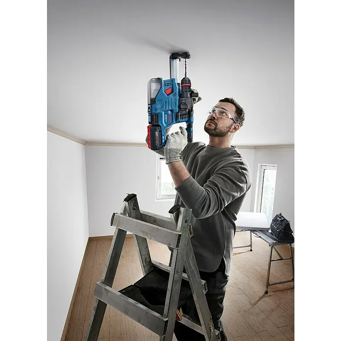 Bosch Professional AMPShare 18V Akku-Bohrhammer GBH 18V-22X - 18 V, Ohne Akku, 2 J - Ein Mann bohrt mit einer Bosch Bohrhammer GBH 18V-28 DC Professional Akku-Bohrhammer in eine Decke, während er auf einer Leiter steht.