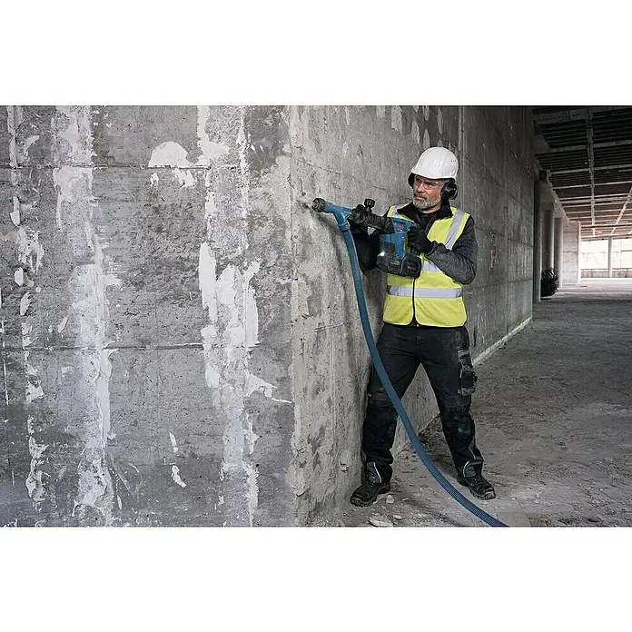 Bosch Professional AMPShare 18V Akku-Schlaghammer GSH 18V-5 - 18 V, Ohne Akku, 8,5 J - Ein Bauarbeiter benutzt einen Bohrhammer mit Staubabsaugung an einer Betonwand. Er trägt Schutzkleidung und sorgt für eine staubfreie Umgebung.