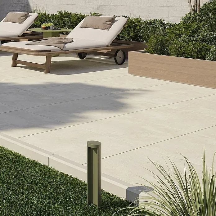 Queens Terrassenfliese - 59,3 x 59,3 x 2 cm, Beige, Matt - Das Bild zeigt eine stilvolle Terrassengestaltung mit einem Fokus auf die hellen Fliesen und einer modernen Liege im Hintergrund.