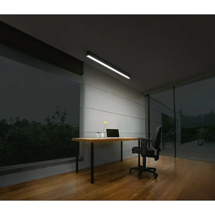 Osram LED-Deckenleuchte Office Line - 30 W, L x B x H: 112,6 x 4,1 x 7 cm, Schwarz, Kaltweiß - Ein moderner Büroraum mit einem Schreibtisch, einem Laptop und einer hellen Deckenleuchte, die den Arbeitsbereich beleuchtet.
