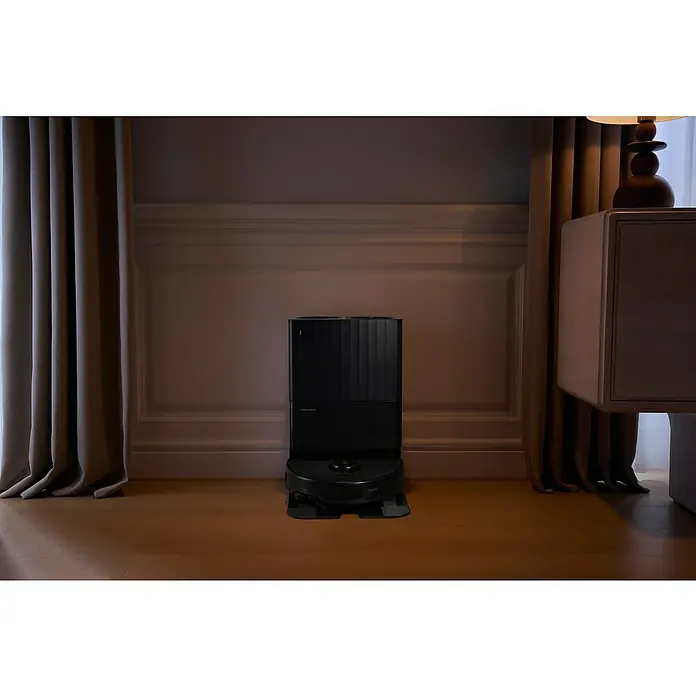 Roborock Saugwischroboter Qrevo Edge 5V1 Black - Saugkraft: 18.500 Pa, Akkulaufzeit: 180 min, Fassungsvermögen Roboter: 325 ml, Schwarz - Ein moderner Roborock Saugroboter mit Ladestation steht auf einem Holzboden vor einer Wand mit Zierleisten.