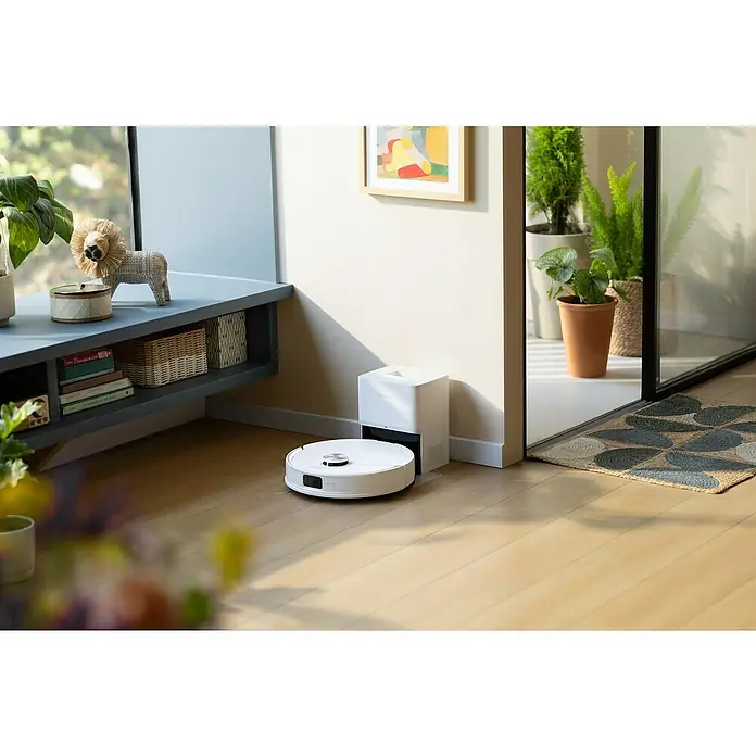Roborock Saugwischroboter Q10 VF+ White - Saugkraft: 10.000 Pa, Akkulaufzeit: 240 min, Fassungsvermögen Roboter: 350 ml, Weiß - Der weiße Saugroboter steht neben seiner Ladestation auf einem hellen Holzboden in einem modern eingerichteten Raum.