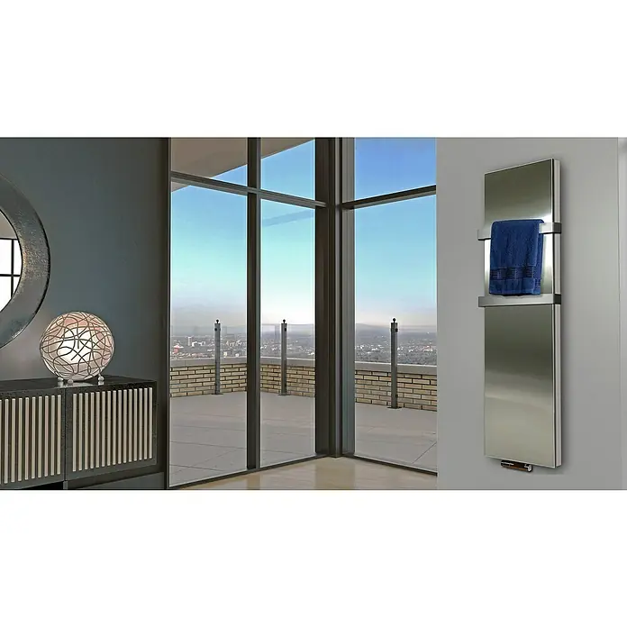 Badheizkörper Manhattan - B x H: 470 x 1.800 mm, Edelstahl, 2 x Halter 50mm, Nennleistung: 1.964 W - Handtuchwärmer aus Stahl mit blauem Handtuch in einem modernen Badezimmer mit Blick auf die Skyline.