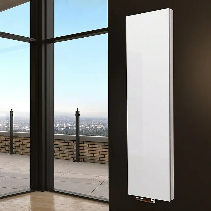 Badheizkörper Manhattan - B x H: 470 x 1.800 mm, Weiß, Ohne Handtuchhalter, Nennleistung: 1.964 W - Ein moderner, schlanker, weißer Heizkörper hängt an einer dunklen Wand, neben einer großen Fensterfront mit Ausblick.