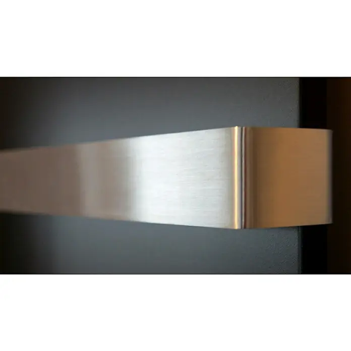 Badheizkörper Manhattan - B x H: 470 x 1.800 mm, Schwarz, 2 x Halter 50mm, Nennleistung: 1.964 W - Nahaufnahme eines modernen, rechteckigen Türgriffs aus gebürstetem Edelstahl an einer dunklen Tür.
