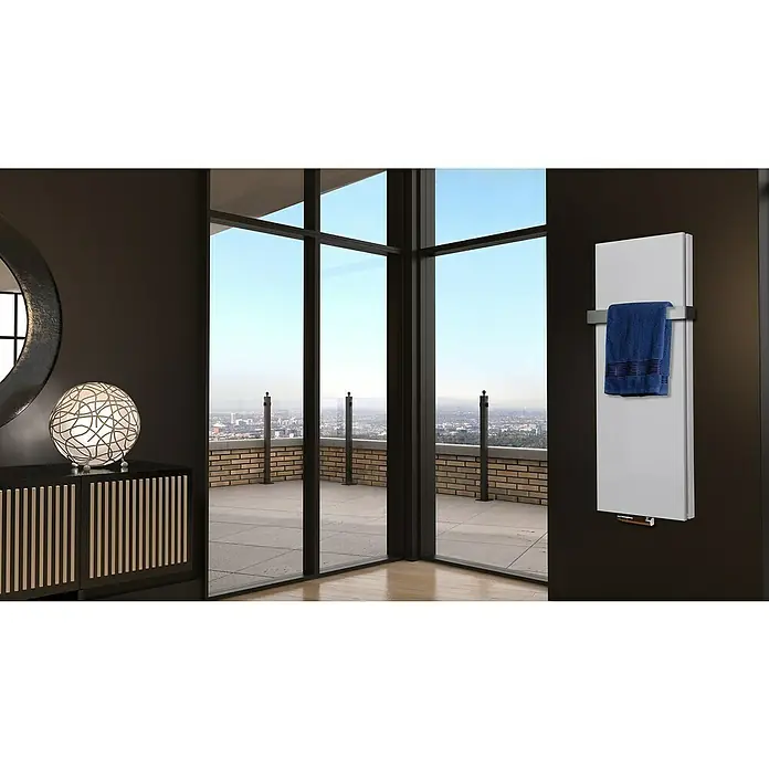 Badheizkörper Manhattan - B x H: 470 x 1.200 mm, Weiß, Mit Halter 50mm, Nennleistung: 1.458 W - Ein moderner, weißer Heizkörper mit einem blauen Handtuch hängt an einer dunklen Wand. Ein stilvolles Detail für jedes Badezimmer.