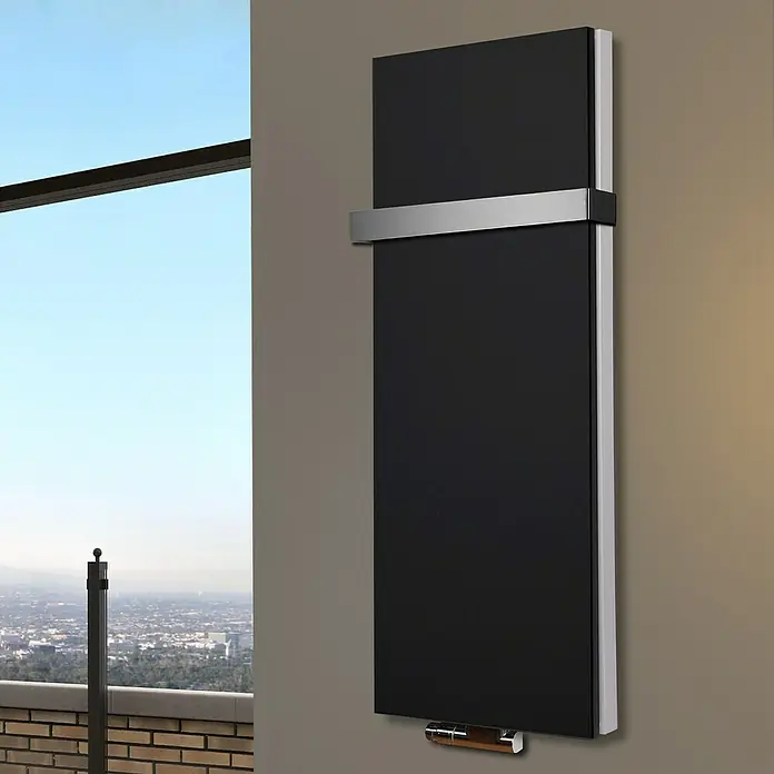 Badheizkörper Manhattan - B x H: 470 x 1.200 mm, Schwarz, Mit Halter 50mm, Nennleistung: 1.458 W - Elegantes, schwarzes Heizpaneel mit silbernen Akzenten, das an einer Wand in einem stilvollen Raum montiert ist. Modernes Design für wohlige Wärme.