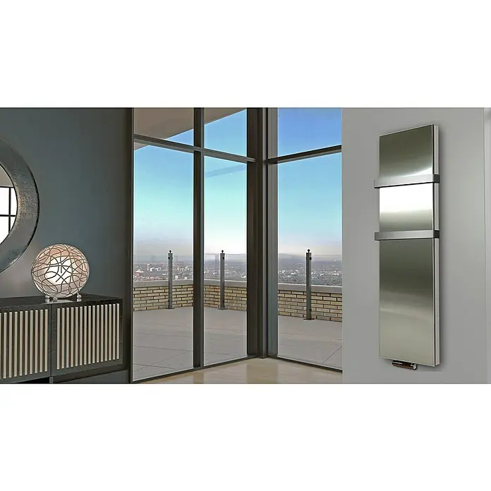 Badheizkörper Manhattan - B x H: 470 x 1.800 mm, Edelstahl, 2 x Halter 50mm, Nennleistung: 1.964 W - Ein moderner, senkrechter Spiegelheizkörper aus Edelstahl hängt an einer grauen Wand und sorgt für Wärme und Stil.