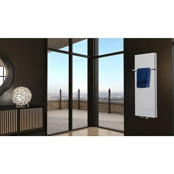 Badheizkörper Manhattan - B x H: 470 x 1.200 mm, Weiß, Mit Halter 15mm, Nennleistung: 1.458 W - Ein moderner, weißer Heizkörper mit Handtuchhalter hängt an einer dunklen Wand in einem stilvollen Badezimmer mit Fensterfront.