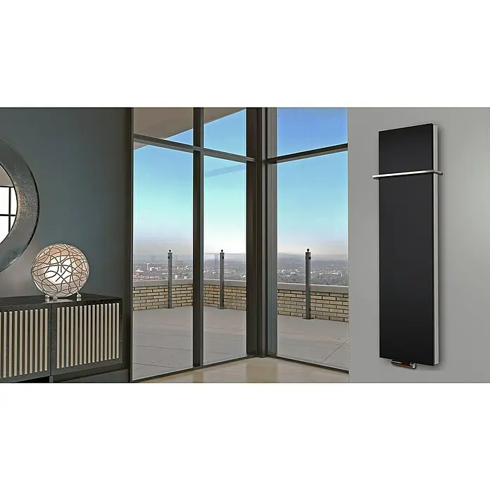 Badheizkörper Manhattan - B x H: 470 x 1.800 mm, Schwarz, 1 x Halter 15mm, Nennleistung: 1.964 W - Elegantes Interieur mit einem modernen Heizkörper an der Wand, ergänzt durch stilvolle Möbel und einen Panoramablick durch große Fenster.