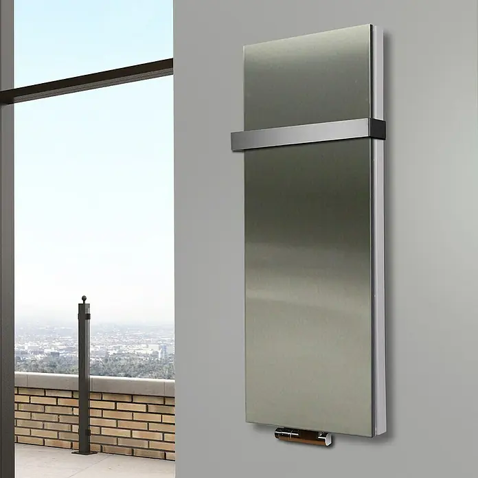 Badheizkörper Manhattan - B x H: 470 x 1.200 mm, Edelstahl, Mit Halter 50mm, Nennleistung: 1.458 W - Ein moderner, silberfarbener Heizkörper hängt an einer grauen Wand und bietet Wärme mit Stil. Eine elegante Ergänzung für jedes Zuhause.