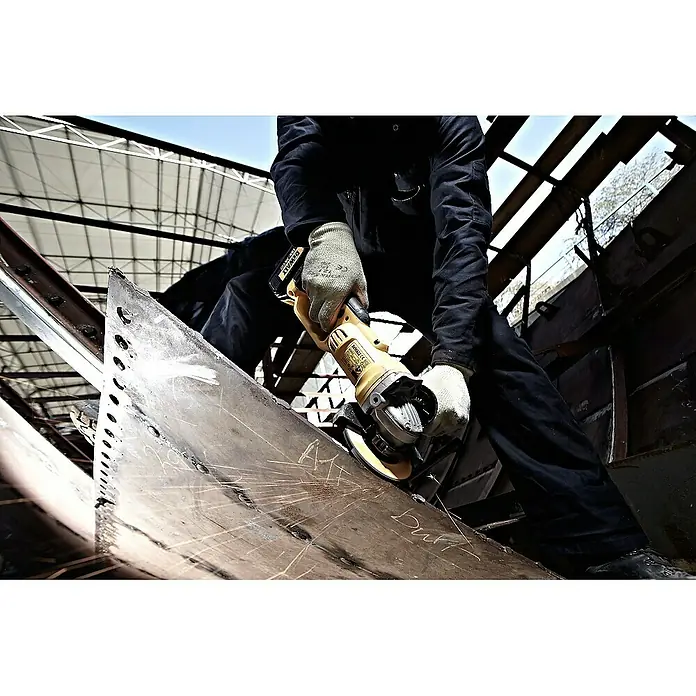 DeWalt XR 18V Akku-Winkelschleifer DCG412M2 - 2 Akkus, 4 Ah, Durchmesser Scheibe: 125 mm - Nahaufnahme eines Handwerkers, der mit einer gelben Schleifmaschine Metall bearbeitet.