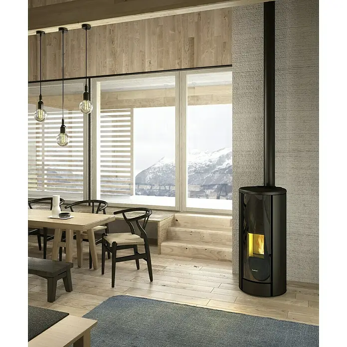 FreePoint Pelletofen Breeze Airtight - 9,1 kW, Raumheizvermögen: 218,4 m³, 0,5 kg/h - 2,1 kg/h, Schwarz - Ein schwarzer Pelletofen von Rika steht in einem modernen Wohnraum mit Holzboden und großen Fenstern. Der Ofen sorgt für Wärme und eine gemütliche Atmosphäre.
