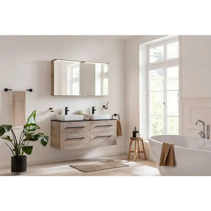 Fackelmann Oxford Waschtischunterschrank - Nature Oak Holzoptik, B x T x H: 600 x 488 x 509 mm - Ein modernes Badezimmer mit einem Waschtischunterschrank in Holzoptik, zwei Waschbecken und einem großen Spiegelschrank. Handtuchhalter und eine Zimmerpflanze vervollständigen das Bild.