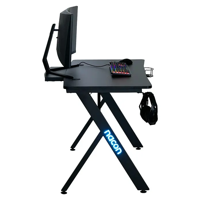 Nacon Mesa de escritorio PCGD-RGB - L x An x Al: 60 x 120 x 75 cm, Iluminación LED, Para Gamers - Mesa de juego con monitor, teclado y ratón en la mesa, además de auriculares y un rótulo iluminado en azul.
