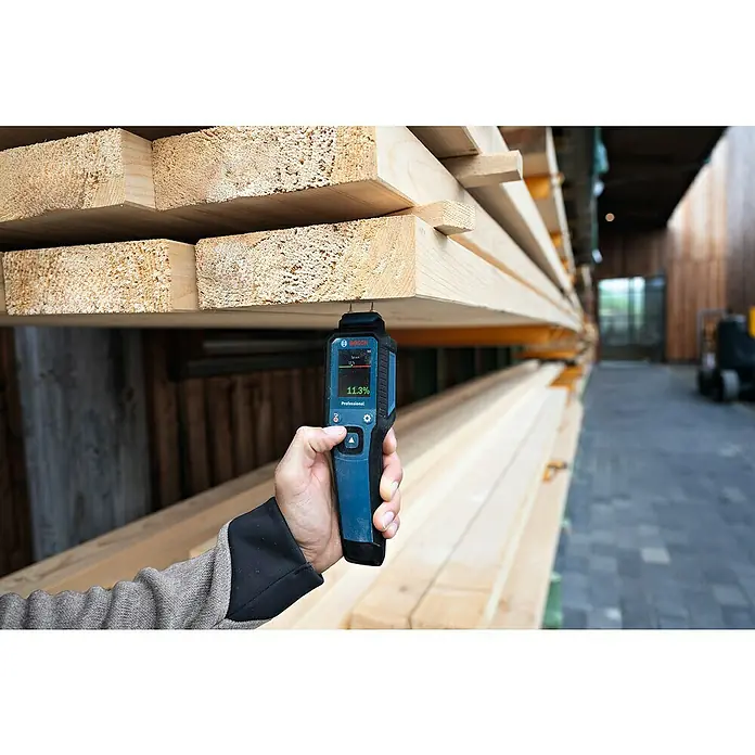 Bosch Feuchtigkeitsmessgerät GMP 1-13 - Messgenauigkeit: Umgebungstemperatur typisch: +/- 1 °C, Mit Batterien - Nahaufnahme eines Bosch Professional Holzfeuchtemessers, das an einem Holzbrett angebracht ist und einen Feuchtigkeitsgehalt von 11,3 % anzeigt.