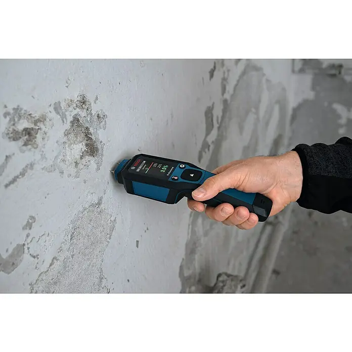 Bosch Feuchtigkeitsmessgerät GMP 2-15 - Messgenauigkeit: Umgebungstemperatur typisch: +/- 1 °C, Mit Batterien - Nahaufnahme eines Bosch Feuchtigkeitsmessgeräts, das an einer Wand mit Feuchtigkeitsschäden verwendet wird, zur Feuchtigkeitsmessung.