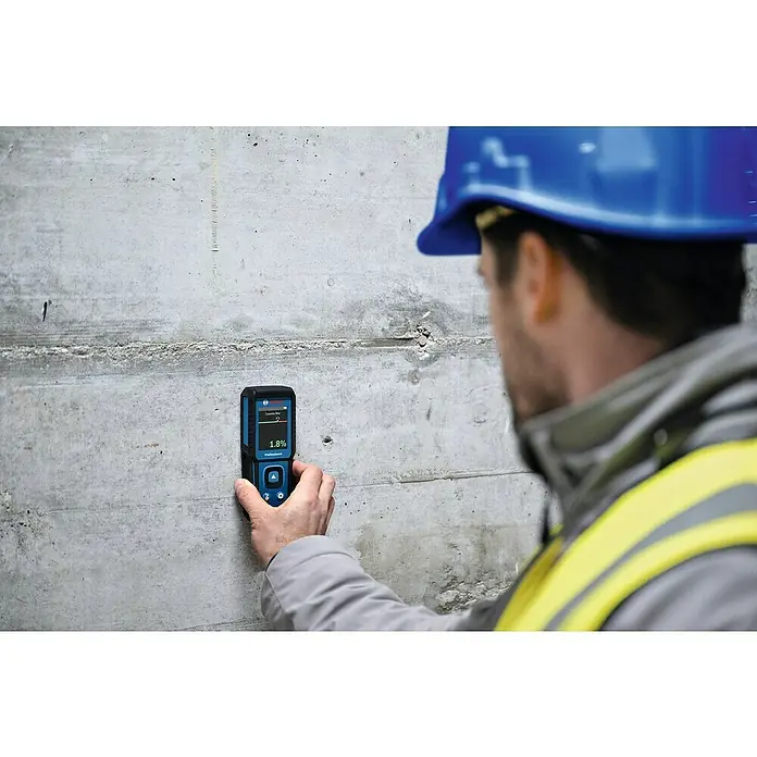 Bosch Feuchtigkeitsmessgerät GMM 1-15 - Messgenauigkeit: ± 0,4 mm/m, Mit Batterien - Ein Bauarbeiter misst mit einem Bosch-Feuchtigkeitsmessgerät den Feuchtigkeitsgehalt in einer Betonwand. Das Gerät zeigt einen Wert von 1,8 % an.