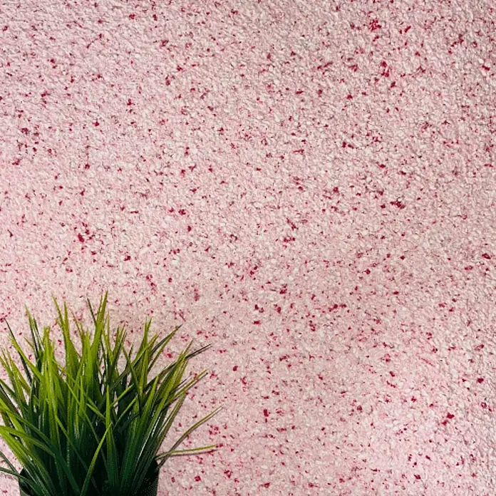 Floxxan Baumwollputz Montana 516 Cellulose - Putz Tapete Flüssigtapete Rot - Flüssigtapete, 1 kg, Lösemittelfrei - Nahaufnahme einer rosafarbenen Tapete mit roten Sprenkeln, die eine strukturierte Oberfläche und ein dekoratives Element zeigt.