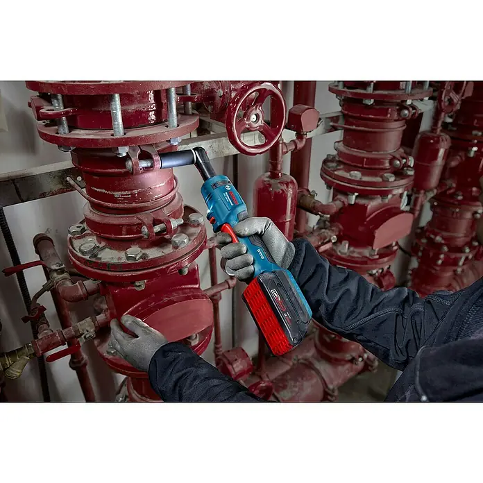 Bosch Professional AMPShare 18V Akku-Ratschenschrauber GRC 18V-60 - Ohne Akku, 400 U/min - Nahaufnahme eines Handwerkers, der mit einem Bosch Akku-Drehschlagschrauber an einer rot lackierten Rohrkonstruktion arbeitet.