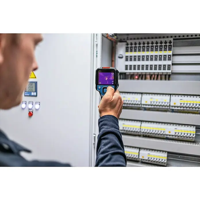 Bosch Professional Wärmebildkamera GTC 12V-450-13 - -20 °C - 450 °C - Ein Mann benutzt eine Wärmebildkamera zur Inspektion eines Sicherungskastens, um potenzielle Überhitzungsprobleme frühzeitig zu erkennen.