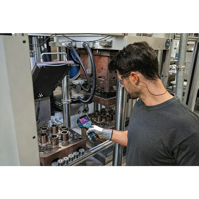 Bosch Professional Wärmebildkamera GTC 12V-450-13 - -20 °C - 450 °C - Ein Arbeiter überprüft die Temperatur einer Industriemaschine mit einer Bosch Wärmebildkamera, um die Effizienz zu prüfen.